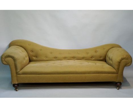 A Victorian buttoned Chesterfield sofa with dished back, buttoned stuffed over arms and seat on turned legs fitted brass cast