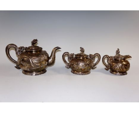 A Chinese three piece silver coloured metal tea service of hammer textured compressed globular form comprising teapot, two ha