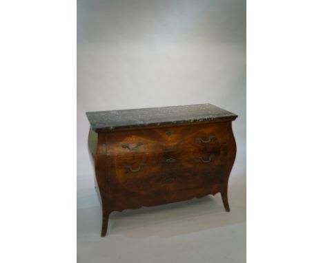 A Continental walnut veneered three drawer commode the veined black marble top above a three drawer front outlined with scrol