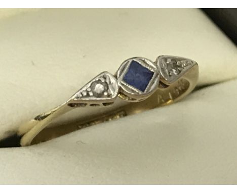 An 18ct gold and platinum Art Decco sapphire and diamond 3 stone dress ring. Central square cut sapphire with two small round