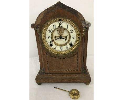 A vintage wooden cased Ansonia Clock Co mantel clock with ceramic skeleton dial. Inlaid detail to front of case, on metal bal