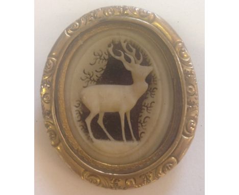 A vintage brooch with central carved panel of a deer.  Approx. 5cm x 4cm.