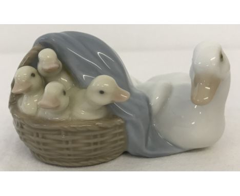 A small Lladro ceramic figurine of a mother duck with a basket of ducklings. #4895 Duckling. In original box. Approx. 5.5cm x