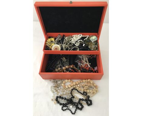 A vintage orange jewellery box containing a quantity of vintage jewellery. To include natural stones, glass necklaces, earrin