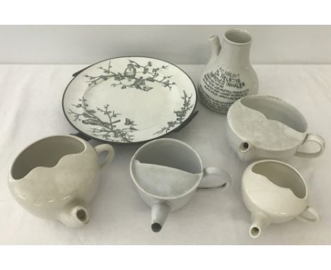 A collection of vintage ceramic and enamel feeding cups together with a Dr Nelsons Inhaler and a ceramic and metal warming pl