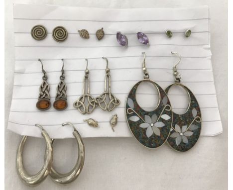 9 pairs of silver earrings. To include 5 pairs of stud earrings, one set with amethysts, one set with peridot and a pair in t