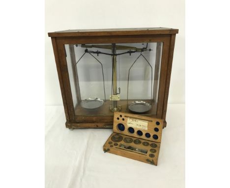 A set of vintage scientific scales with a boxed set of weights by Philip Harris & Co Ltd. Complete with glass case. 