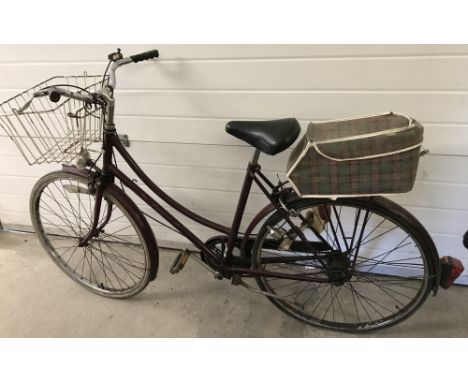 A vintage ladies  Raleigh Cameo bicycle. Marron painted frame with front basket and rear saddle bag. Lights fitted to front a