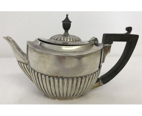 A hallmarked antique silver Bachelors teapot with half fluted design. Wooden handle and finial to lid. London assay mark but 