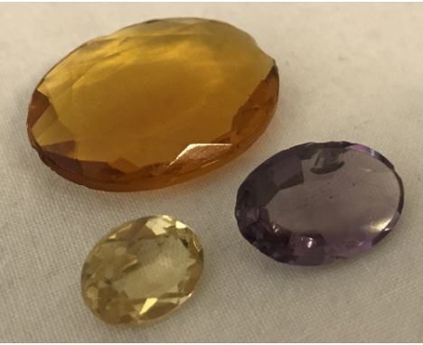 3 unset semi precious stones. Large deep coloured citrine, a pale citrine and an amethyst. All stones are oval cut with chips