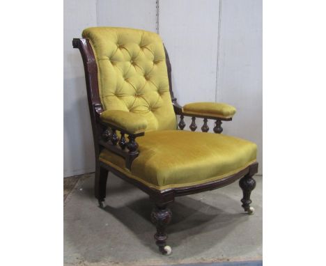 A Victorian drawing room chair with mustard coloured upholstered seat, button back and arms within a mahogany show wood frame