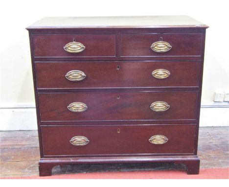 A Georgian mahogany bedroom chest of two short over three long graduated oak lined drawers with associated oval embossed bras
