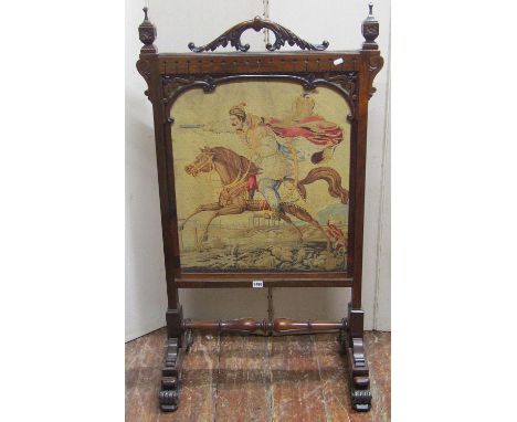 A 19th century rosewood firescreen with carved and moulded framework enclosing a tapestry panel of a cavalry man on horse bac