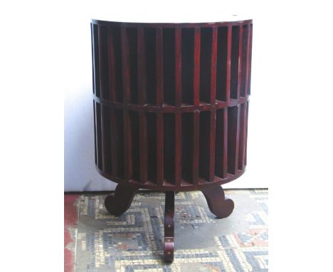 An Indian hardwood floorstanding revolving cylindrical unit with shallow segmented compartments and inlaid floral brass bande