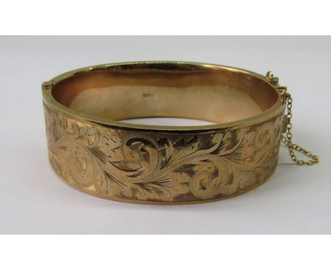1960s 9ct hinged bangle with engraved scrolled decoration, maker 'H.G &amp; S', 26.6g 