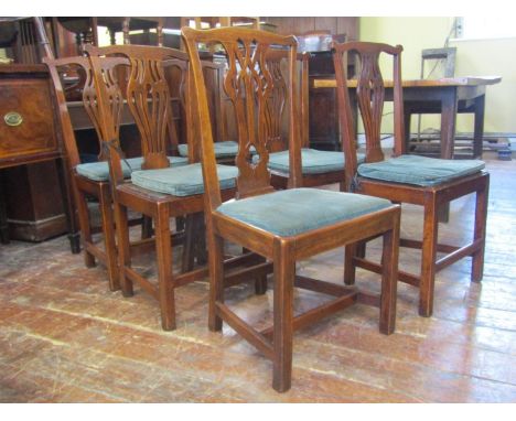 A set of five Georgian oak country made dining chairs in the Chippendale style with pierced vase shaped splats over solid sea