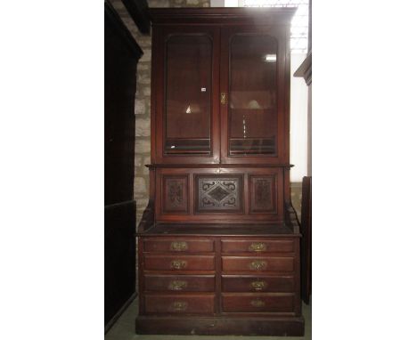 A late Victorian mahogany secretaire bookcase, the upper section enclosed by a pair of glazed arched moulded panelled doors w