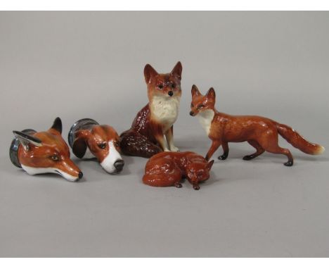 A Beswick model of a recumbent fox, a Beswick model of a running fox, a pair of Royale Stratford stirrup cups in the form of 