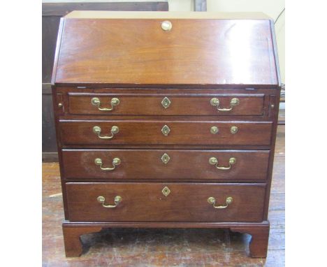 A Georgian mahogany bureau, the fall flap enclosing a fitted interior of small drawers and pigeon holes flanking a central cu