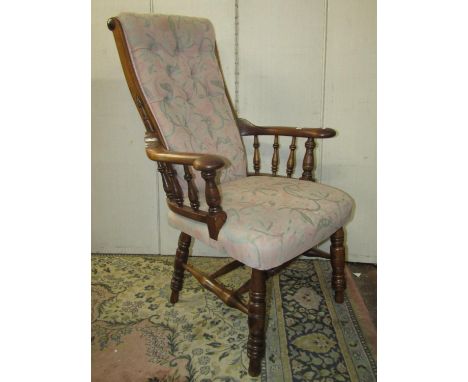 An unusual Windsor style armchair with upholstered seat button back over shaped arms raised on turned supports and stretchers