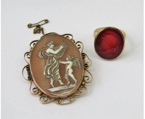 9ct intaglio cut carnelian ring depicting a centurion, maker 'FM', size P/Q, 5.1g, together with a scrolled 9ct cameo brooch 