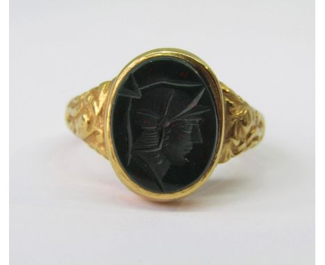 9ct intaglio-cut bloodstone ring depicting a centurion, with cast scrolled decoration to shoulders, maker 'DHJ', size T, 5.5g