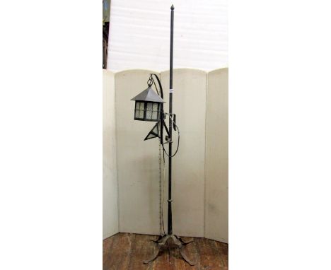 An Old English/Arts and Crafts style iron work floorstanding standard lamp with adjustable rise and fall bracket supporting a