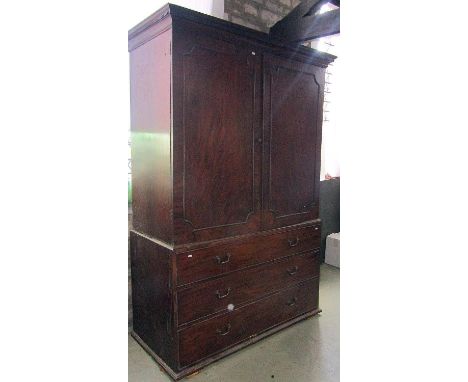 A substantial broad Georgian mahogany linen press with dentil cornice over a pair of rectangular moulded panelled doors with 