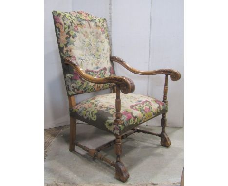 A Carolean style open armchair with floral tapestry upholstered seat and back, scrolled acanthus arms raised on partially tur