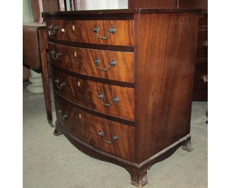 A small 19th century mahogany bow fronted chest of four long graduated drawers with well matched flame veneers, over a shaped