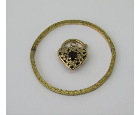 9ct heart shaped clasp set with a garnet and with pierced floral decoration, 5.3g, together with an engraved gilt metal chris