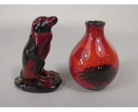 A Royal Doulton flambe model of a penguin, 14.5 cm tall approx, together with a Poole Pottery flambe vase with tree design, 1