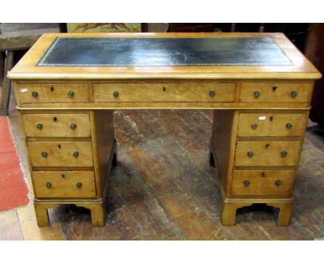 A small Victorian faded mahogany kneehole twin pedestal writing desk with inset leather panelled top over the usual arrangeme