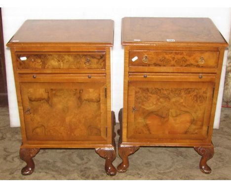 A matched pair of walnut veneered bedside cupboards/lamp tables, each enclosed by a single door beneath a brushing slide and 