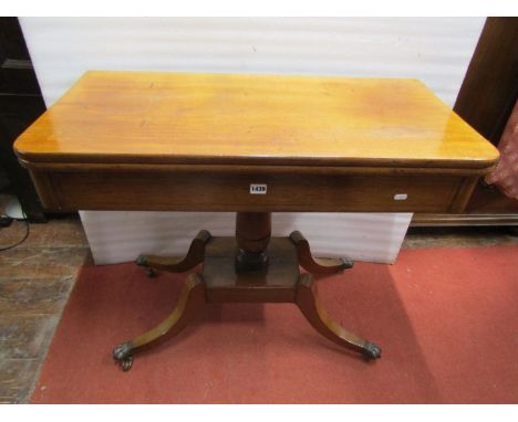A 19th century pale mahogany fold over top tea table of rectangular form with rounded front corners raised on a central turne