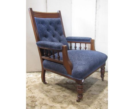 An Edwardian drawing room chair with upholstered seat and button back within a moulded oak show wood frame raised on turned f