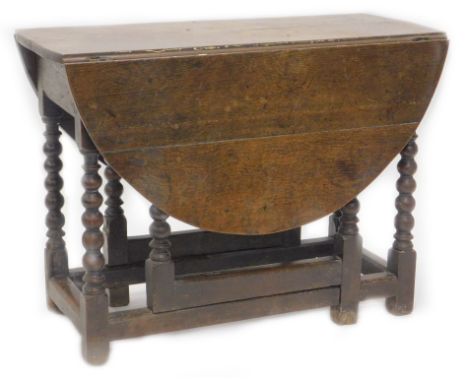 An 18thC oak gate leg table, the oval top on bobbin turned supports, 90cm W.