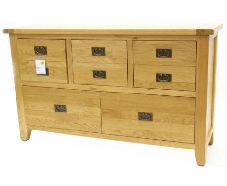 An ex shop display Hampton Court oak chest or small sideboard, with three frieze drawers above four deeper drawers, on bracke
