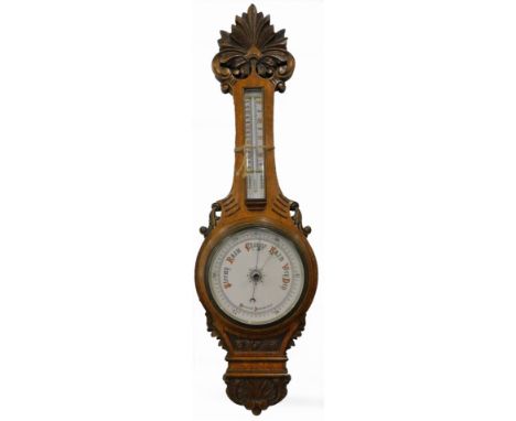 A late Victorian aneroid barometer, in a carved banjo shaped case, decorated with scrolls, leaves, etc., the ceramic dial cal
