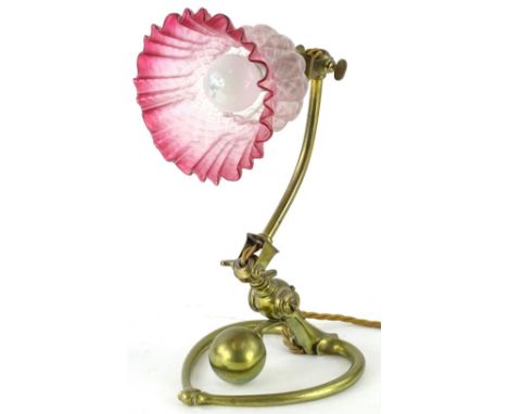 An unusual late 19th/early 20thC brass adjustable table lamp, with red tinted opaque shade, indistinctly stamped, possibly Be