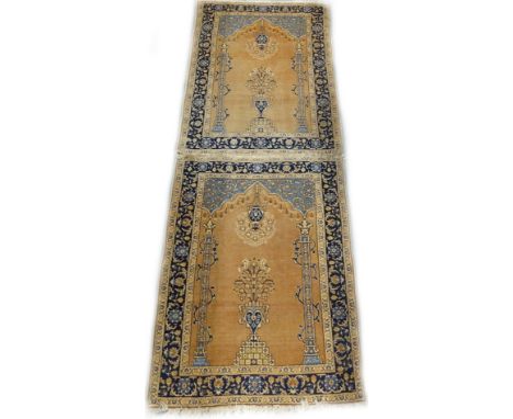 A near pair of Persian type prayer rugs, each with a mihrab, a hanging lantern, vase of flowers and a pair of pillows, one wi