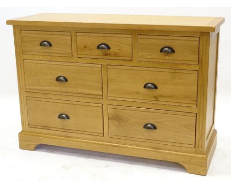 An ex shop display Hampton Court natural oak chest of drawers or small sideboard, with three frieze drawers above four larger