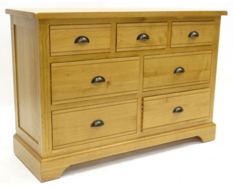 An ex shop display Hampton Court oak sideboard or chest of drawers, with an arrangement of three small and four large drawers