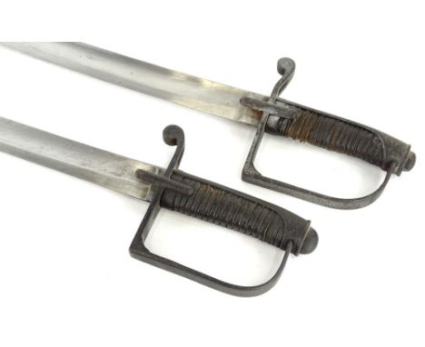 A pair of 19thC military type sabers, each with a blackened iron scabbard, and a wooden handle with woven decoration, possibl