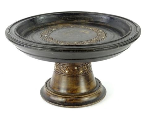 An Eastern ebonised stand, the turned circular top with geometric decoration and mother of pearl inlay, on a domed foot, 25cm