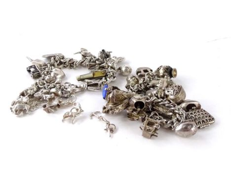 Two silver charm bracelets, to include one formed of a watch chain, with various charms, include bus, kangaroo, windmill, tri