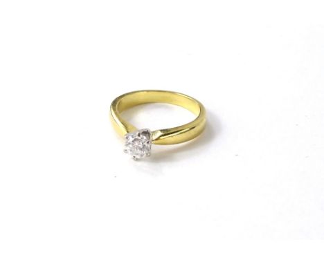 An 18ct gold diamond solitaire ring, with round brilliant cut diamond, in platinum raised six claw setting, on yellow metal b