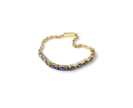 A sapphire and diamond bracelet, with central design of eleven oval cut sapphires in four claw setting, broken by two round b