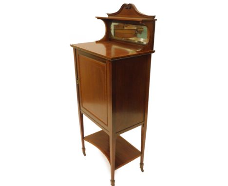 An Edwardian mahogany and satinwood crossbanded music cabinet, the raised back with a shaped crest shelf above a rectangular 