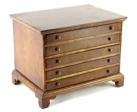 A walnut collectors miniature chest in George III style, with a crossbanded top above five long drawers, each with brass hand